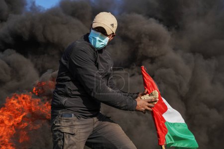 Foto de Palestinians demonstrate on the borders of the Gaza Strip. February 22, 2023, Gaza, Palestine: Palestinian youth set fire to rubber tires on the eastern borders of the Gaza Strip - Imagen libre de derechos