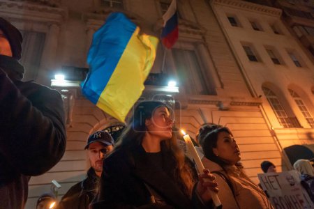 Photo for Candlelight Vigil For Ukraine's Resilience and Resistance. February 23, 2023, New York, USA: People with Ukrainian Flags, anti-war sign and candles gather at a candlelight vigil on the eve of the one year anniversary of full-scale Russian invasion - Royalty Free Image