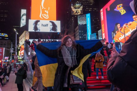 Téléchargez les photos : Des gens de toute l'Amérique du Nord se rassemblent pour soutenir l'Ukraine à l'occasion de l'anniversaire de l'invasion russe. 24 février 2023, New York, New York, USA : Femme avec un drapeau ukrainien pose lors d'une manifestation de la guerre en Ukraine à l'occasion de son anniversaire d'un an - en image libre de droit