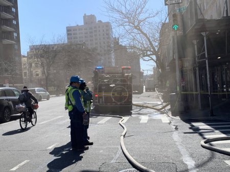 Photo for (NEW) Firemen at work trying to contain fire due to electrical problems. March 16, 2023, New York, USA: Firemen are seen at work trying to contain fire due to electrical problems at 410 W 24th street with 9th Avenue - Royalty Free Image