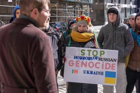 Foto de Ceremonia de izamiento de Bandera Ucraniana. 19 de marzo de 2023, Nueva York, Nueva York, Estados Unidos: Un hombre sostiene una señal de STOP HORRORS OF RUSSIAN GENOCIDE IN UCRANIA en una ceremonia de izado de la bandera ucraniana para mostrar solidaridad con el pueblo ucraniano - Imagen libre de derechos