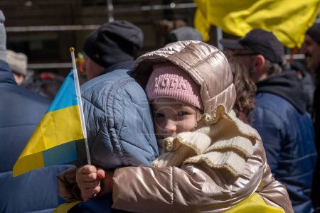 Photo for Ukrainian Flag Raising Ceremony. March 19, 2023, New York, New York, USA: Zlata, 8 years old, holds an Ukrainian flag at a Ukrainian flag raising ceremony to show solidarity with the Ukrainian people at the historic Bowling Green Park - Royalty Free Image