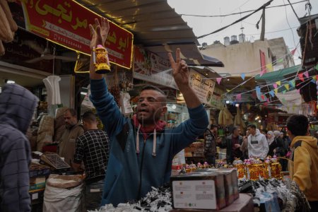 Téléchargez les photos : (INT) Les Palestiniens magasinent et se préparent à recevoir le mois du Ramadan. 21 mars 2023, Gaza, Palestine : Des Palestiniens se rendent sur les marchés pour acheter des fournitures pour le mois de Ramadan, telles que des fournitures pour décorer des maisons et acheter de la nourriture. - en image libre de droit