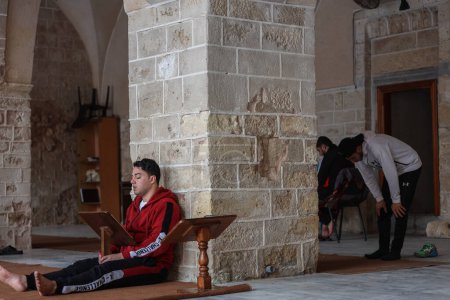 Téléchargez les photos : Les Palestiniens adorent dans les mosquées pendant le Ramadan. 25 mars 2023, Gaza, Palestine : Les musulmans palestiniens de Gaza ont hâte de lire le Coran et d'adorer Dieu après chaque prière dans la mosquée. - en image libre de droit