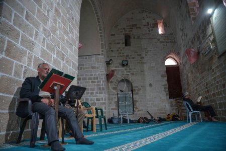Téléchargez les photos : Les Palestiniens adorent dans les mosquées pendant le Ramadan. 25 mars 2023, Gaza, Palestine : Les musulmans palestiniens de Gaza ont hâte de lire le Coran et d'adorer Dieu après chaque prière dans la mosquée. - en image libre de droit
