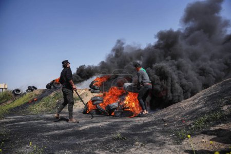 Foto de (INT) Jóvenes palestinos incendian neumáticos de goma en las fronteras de la Franja de Gaza. 5 de abril de 2023, Gaza, Palestina: Decenas de jóvenes palestinos incendian neumáticos de goma en las fronteras orientales de la Franja de Gaza - Imagen libre de derechos