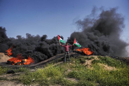Photo for (INT) Palestinian youths set fire to rubber tires on the borders of Gaza Strip. April 5, 2023, Gaza, Palestine: Dozens of Palestinian youths set fire to rubber tires on the eastern borders of Gaza Strip - Royalty Free Image