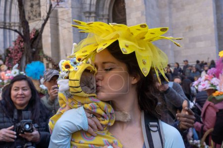 Photo for 2023 New York City Easter Bonnet Parade. April 09, 2023, New York, New York, USA: A woman kisses her cat during the Easter Parade and Bonnet Festival 2023 outside St. Patrick's Cathedral along Fifth Avenue on Easter Sunday, April 9, 2023 - Royalty Free Image
