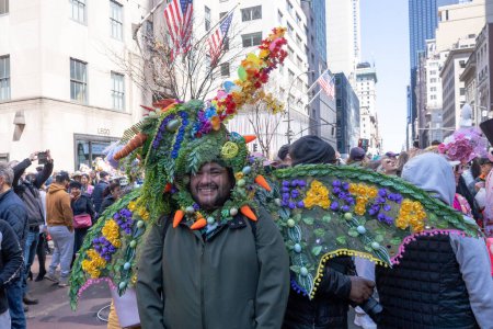 Photo for 2023 New York City Easter Bonnet Parade. April 09, 2023, New York, New York, USA: Eduardo Escobar wears folding wings and decorated head piece attends the Easter Parade and Bonnet Festival 2023 outside St. Patrick's Cathedral - Royalty Free Image
