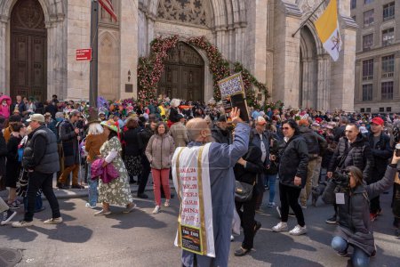 Photo for 2023 New York City Easter Bonnet Parade. April 09, 2023, New York, New York, USA: A man preaches to repent before the end of the world outside St. Patrick's Cathedral along Fifth Avenue at the Easter Parade and Bonnet Festival 2023 on Easter - Royalty Free Image