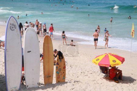 Téléchargez les photos : Les baigneurs prennent d'assaut Arpoador Beach à Rio. 15 avril 2023, Rio de Janeiro, Brésil : Les touristes et les habitants profitent du soleil à Praia do Arpoador, dans la zone sud de Rio de Janeiro le samedi (15) - en image libre de droit