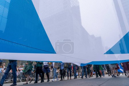 Téléchargez les photos : 25e défilé annuel du jour du tartan à New York. 15 avril 2023, New York, New York, États-Unis : Les participants portant un grand drapeau écossais défilent lors de la 25e Parade annuelle du Jour du Tartan à Manhattan le 15 avril 2023 à New York. - en image libre de droit