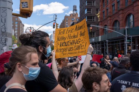 Photo for Outrage Grows After Chokehold Death Of Man On Subway. May 06, 2023, New York, New York, USA: Protester holds Tell Eric Adams Kathy Hochul that HOUSING keeps us safe! sign during a march from the Broadway-Lafayette subway station - Royalty Free Image