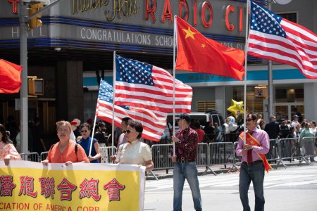 Photo for Asian men with American and Chinese flags at the second annual AAPI Parade on Sixth Avenue (Avenue of the Americas). May 21, 2023. New York, USA The Asian American and Pacific Islander (AAPI) Cultural and Heritage Parade - Royalty Free Image