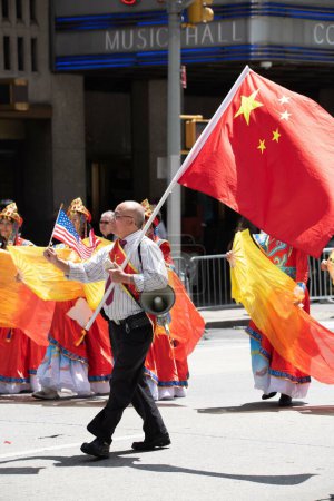 Photo for A man with an Amaerican and Chinese flags at the second annual AAPI Parade on Sixth Avenue (Avenue of the Americas). May 21, 2023. New York, USA The Asian American and Pacific Islander (AAPI) Cultural and Heritage Parade - Royalty Free Image