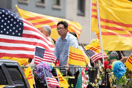 Photo for Young man with American and Vietnamese flags at the second annual AAPI Parade on Sixth Avenue (Avenue of the Americas). May 21, 2023. New York, USA The Asian American and Pacific Islander (AAPI) Cultural and Heritage Parade comes - Royalty Free Image
