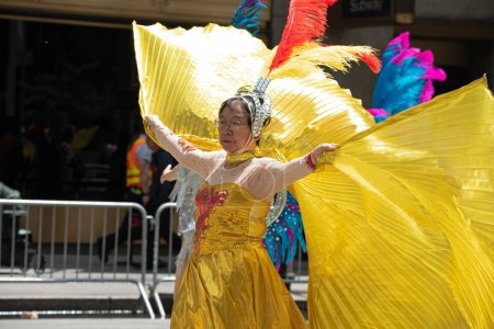 Téléchargez les photos : Danseuse aux ailes dorées, habillez-vous lors du deuxième défilé annuel de l'AAPI sur la Sixième Avenue (Avenue des Amériques). Le 21 mai 2023. New York, États-Unis Défilé culturel et patrimonial des Asiatiques américains et du Pacifique (AAPI) - en image libre de droit