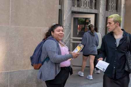 Photo for Protest To Stop The Con Ed Rate Hikes!. May 31, 2023, New York, New York, USA: Carol, Kei , Edmond speak while other activists hand out leaflets to pedestrians during a protest to stop Con Ed rate hikes organized by NYC Party for Socialism - Royalty Free Image