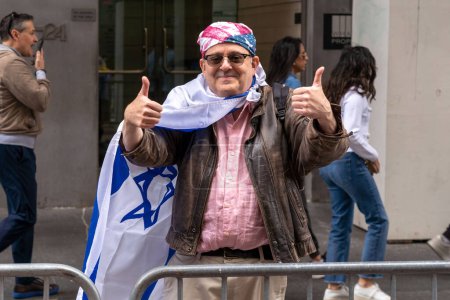Téléchargez les photos : Célébrez la parade d'Israël en 2023. 04 juin 2023, New York, New York, USA : Un spectateur drapé du drapeau israélien pose sur la Cinquième Avenue lors du Celebrate Israel Parade le 4 juin 2023 à New York. - en image libre de droit