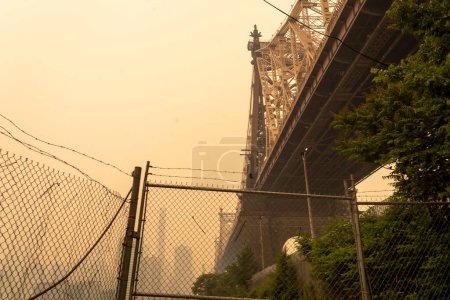Téléchargez les photos : Smoke From Canadian Wildfires Blows South Creating Hazy Conditions On Large Swath Of Eastern U.S.. juin 07, 2023, New York, New York, États-Unis : En milieu d'après-midi, la fumée des feux de forêt canadiens couvre le pont Queensboro - en image libre de droit