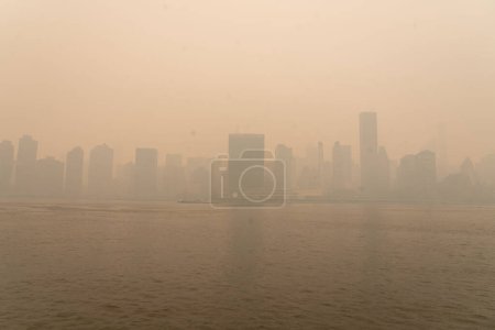 Photo for Smoke From Canadian Wildfires Blows South Creating Hazy Conditions On Large Swath Of Eastern U.S.. June 07, 2023, New York, New York, USA: In the middle of the afternoon, smoke from Canadian forest fires blankets the skyline of New York City - Royalty Free Image