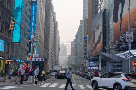 Photo for Smoke From Canadian Wildfires Blows South Creating Hazy Conditions On Large Swath Of Eastern U.S.. June 07, 2023, New York, New York, USA: People make their way around Times Square amid smoke from Canadian forest fires that blankets the skyline - Royalty Free Image