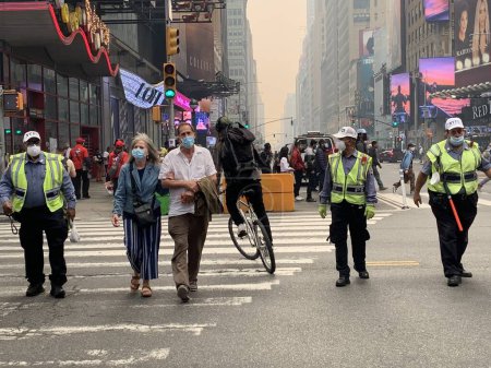 Téléchargez les photos : Time Square-NYC Under Smoke from Canada's Fires. 7 juin 2023, New York, États-Unis : Tout l'air de New York a été pollué par de la fumée provenant du Canada, ce qui a amené les New-Yorkais et les touristes à Times Square à se masquer pour éviter d'être contaminés - en image libre de droit