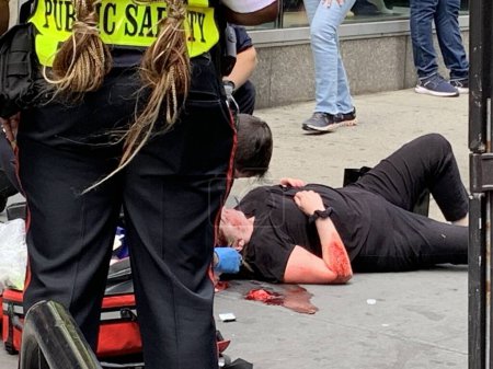 Photo for A woman fell and got injured at Times Square. June 15, 2023, New York, USA: A woman fell down and got injured with blood coming out around her neck and arm at Times Square and had to be given first aid treatment by FDNY - Royalty Free Image