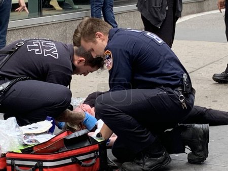 Foto de Una mujer cayó y se lesionó en Times Square. 15 de junio de 2023, Nueva York, Estados Unidos: Una mujer cayó y se lesionó con sangre saliendo alrededor de su cuello y brazo en Times Square y tuvo que recibir tratamiento de primeros auxilios por parte del FDNY - Imagen libre de derechos