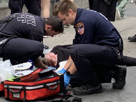 Photo for A woman fell and got injured at Times Square. June 15, 2023, New York, USA: A woman fell down and got injured with blood coming out around her neck and arm at Times Square and had to be given first aid treatment by FDNY - Royalty Free Image