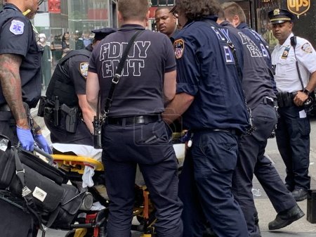 Foto de Una mujer cayó y se lesionó en Times Square. 15 de junio de 2023, Nueva York, Estados Unidos: Una mujer cayó y se lesionó con sangre saliendo alrededor de su cuello y brazo en Times Square y tuvo que recibir tratamiento de primeros auxilios por parte del FDNY - Imagen libre de derechos