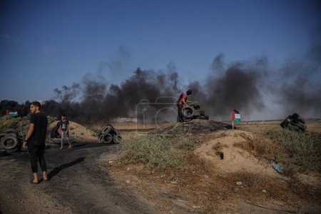 Foto de Jóvenes palestinos incendiaron neumáticos de goma en las fronteras orientales de la Franja de Gaza. 19 de junio de 2023, Gaza, Palestina: Jóvenes palestinos incendian neumáticos de goma en las fronteras de la Franja de Gaza - Imagen libre de derechos
