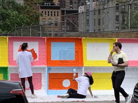 Téléchargez les photos : (NEW) Volunteers Peignez des murs à Manhattan. 21 juin 2023, New York, États-Unis : Des bénévoles de l'immobilier décident de dessiner et de peindre des murs le long de 37 rue entre la 9e et la 10e avenue à Manhattan, New York. - en image libre de droit