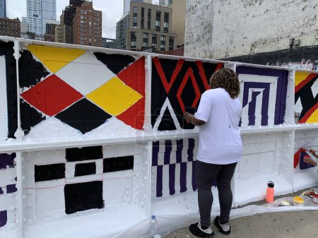 Téléchargez les photos : (NEW) Volunteers Peignez des murs à Manhattan. 21 juin 2023, New York, États-Unis : Des bénévoles de l'immobilier décident de dessiner et de peindre des murs le long de 37 rue entre la 9e et la 10e avenue à Manhattan, New York. - en image libre de droit
