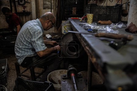 Photo for Preparations for Eid al-Adha. June 25, 2023 Gaza, Palestine: Palestinian workers work inside the Al-Fari shop in the center of the Gaza Strip, which specializes in sharpening and preparing knives and sharp tools for Palestinian butchers - Royalty Free Image