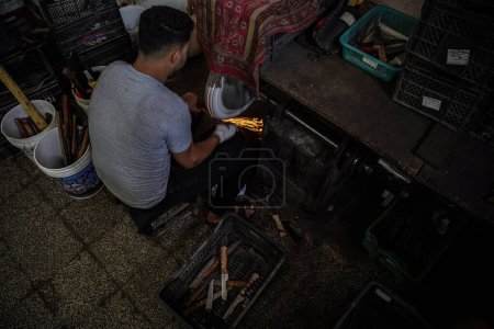 Photo for Preparations for Eid al-Adha. June 25, 2023 Gaza, Palestine: Palestinian workers work inside the Al-Fari shop in the center of the Gaza Strip, which specializes in sharpening and preparing knives and sharp tools for Palestinian butchers - Royalty Free Image