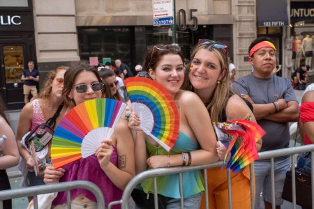 Téléchargez les photos : 2023 New York City Pride March. 25 juin 2023, New York, New York, USA : Des spectateurs avec des drapeaux de fierté regardent le défilé annuel de la fierté de New York le 25 juin 2023 à New York. - en image libre de droit