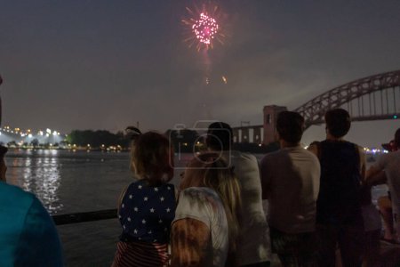 Photo for (NEW) Independence Day Celebrations. June 29, 2023, New York, New York, USA: Woman and her child watch fireworks explode during the Central Astoria annual Independence Day Celebrations fireworks display in Astoria Park on June 29th, 2023 - Royalty Free Image