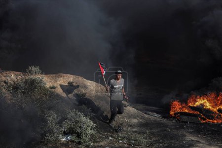 Téléchargez les photos : (INT) Des jeunes Palestiniens ont mis le feu à des pneus en caoutchouc le long de la frontière orientale de la bande de Gaza. 3 juillet 2023, Gaza, Palestine : Des jeunes Palestiniens brûlent des pneus en caoutchouc à la frontière Est de Gaza pour exprimer leur colère - en image libre de droit