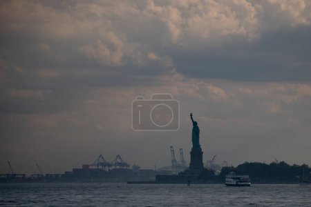 Photo for New York, USA - 07/03/2023 - CLIMATE/TRANSFERENCE/NEW YORK/USA - Statue of Liberty and Liberty Island in New York Harbor. View from Battery Park - Royalty Free Image