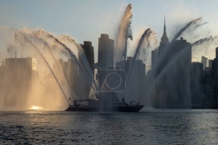 Téléchargez les photos : (NOUVEAU) New York célèbre le jour de l'indépendance. 04 juillet 2023, New York, New York, États-Unis : Un bateau du Service d'incendie de New York (NYFD) pulvérise de l'eau en rouge, blanc et bleu pendant le 4 juillet annuel de Macy's - en image libre de droit