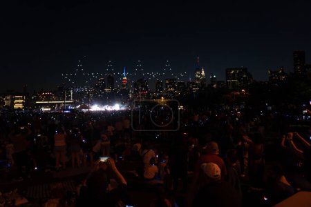 Photo for (NEW) New York City Celebrates Independence Day. July 04, 2023, New York, New York, USA: Drones perform a light show before the annual Macy's 4th of July Fireworks display overlooking the Manhattan skyline at Gantry State Plaza Park in Long Island - Royalty Free Image