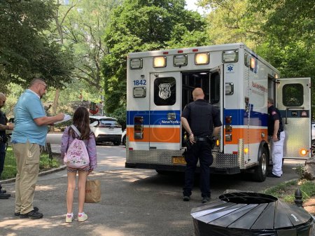 Téléchargez les photos : New York, États-Unis - 12 juillet 2023 : Une femme a été soignée par des ambulanciers paramédicaux juste à l'intérieur d'une ambulance au zoo de Central Park et il n'était pas nécessaire d'aller à l'hôpital. Elle se sentait mieux après. Selon une travailleuse du parc, la femme se plaignait de ne pas se sentir bien - en image libre de droit