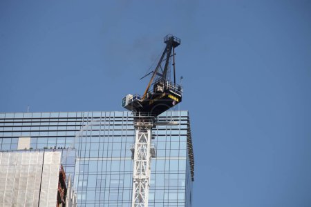 Photo for Crane catches fire and collapses in Manhattan-NYC. July 26, 2023, New York, USA: A construction crane catches fire and collapses on a skyscraper in midtown Manhattan in New York City early Wednesday morning, sending black smoke billowing into the sky - Royalty Free Image