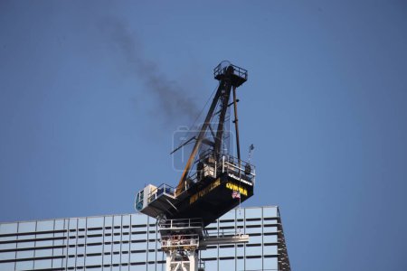 Photo for Crane catches fire and collapses in Manhattan-NYC. July 26, 2023, New York, USA: A construction crane catches fire and collapses on a skyscraper in midtown Manhattan in New York City early Wednesday morning, sending black smoke billowing into the sky - Royalty Free Image
