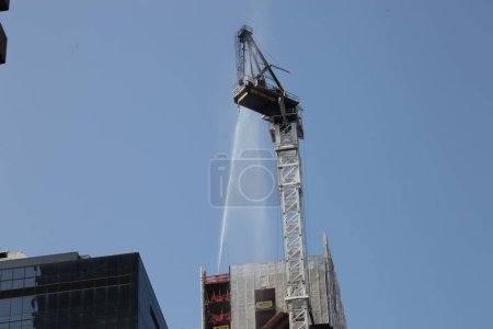 Photo for Construction Crane catches Fire and collapses in Manhattan-NYC. July 26, 2023, New York, USA: A construction crane catches fire and collapses on a skyscraper with about 45 floors in mid Manhattan, New York City early morning of Wednesday (26), - Royalty Free Image