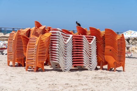Foto de La vida cotidiana en Israel Verano 2023. 21 de julio de 2023, Tel Aviv, Israel: Una pila de sillas de playa no utilizadas vistas en la playa de Tel Baruch el 21 de julio de 2023 en Tel Aviv, Israel. - Imagen libre de derechos