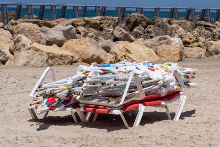 Foto de La vida cotidiana en Israel Verano 2023. 21 de julio de 2023, Tel Aviv, Israel: Una pila de sombrillas de playa sin usar vistas en la playa de Tel Baruch el 21 de julio de 2023 en Tel Aviv, Israel. - Imagen libre de derechos