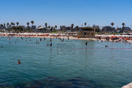Foto de La vida cotidiana en Israel Verano 2023. 21 de julio de 2023, Tel Aviv, Israel: Personas tomando un baño en aguas marinas en la playa de Tel Baruch el 21 de julio de 2023 en Tel Aviv, Israel. - Imagen libre de derechos