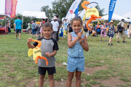 Photo for Hong Kong Dragon Boat Festival in New York (HKDBF-NY). August 12, 2023, New York, New York, USA:Hayes, age 4, and Raquel, age 6, hold a dragon during the 31st Hong Kong Dragon Boat Festival in New York (HKDBF-NY) at Flushing Meadows Corona Park - Royalty Free Image
